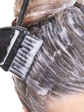 Eine Frau trägt Haarfärbung in Balayage-Technik auf