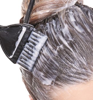 Eine Frau trägt Haarfärbung in Balayage-Technik auf
