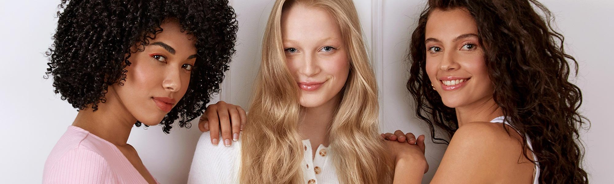 Drei Frauen mit verschiedenen Haarfarben und gelockten & gewellten Haaren