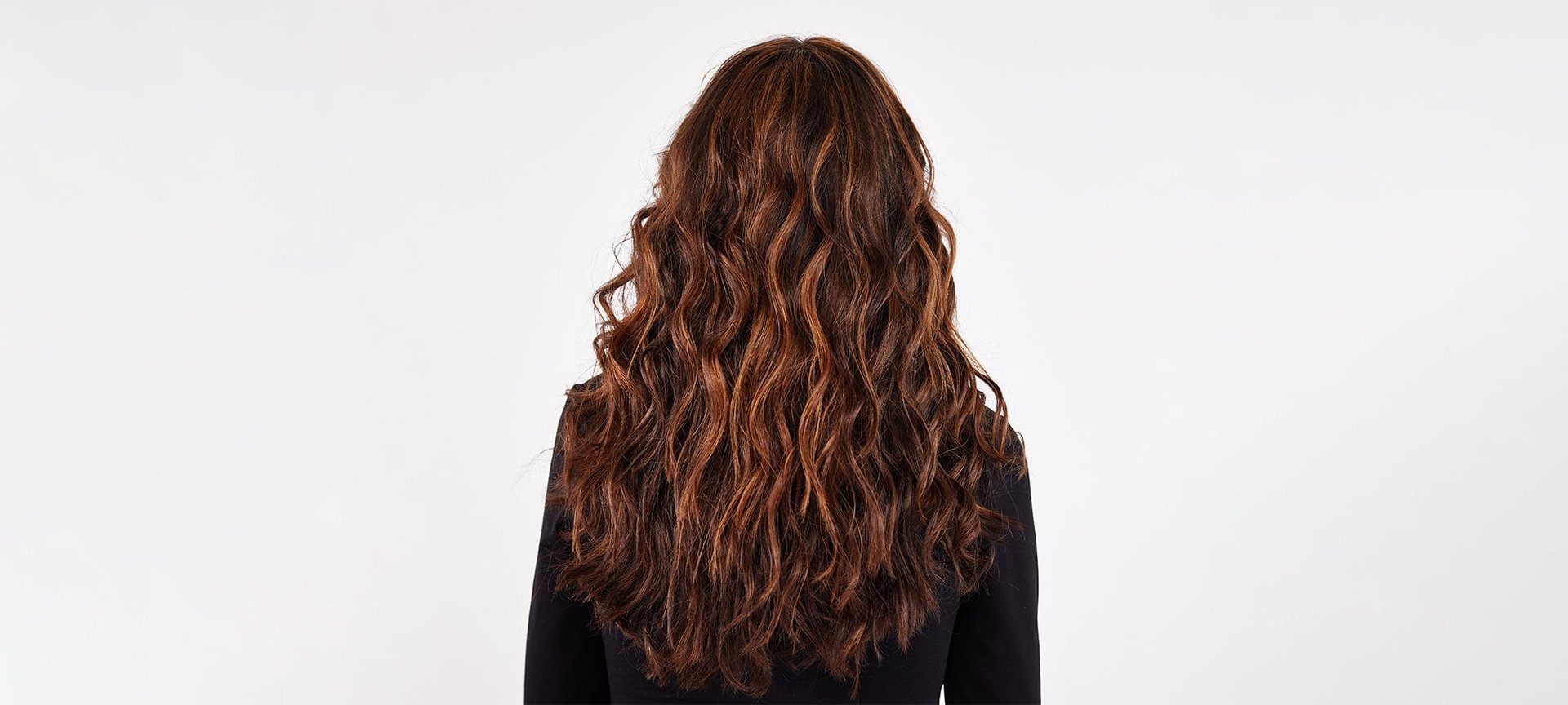 Rückansicht einer Frau mit langen gewellten braunen Haaren