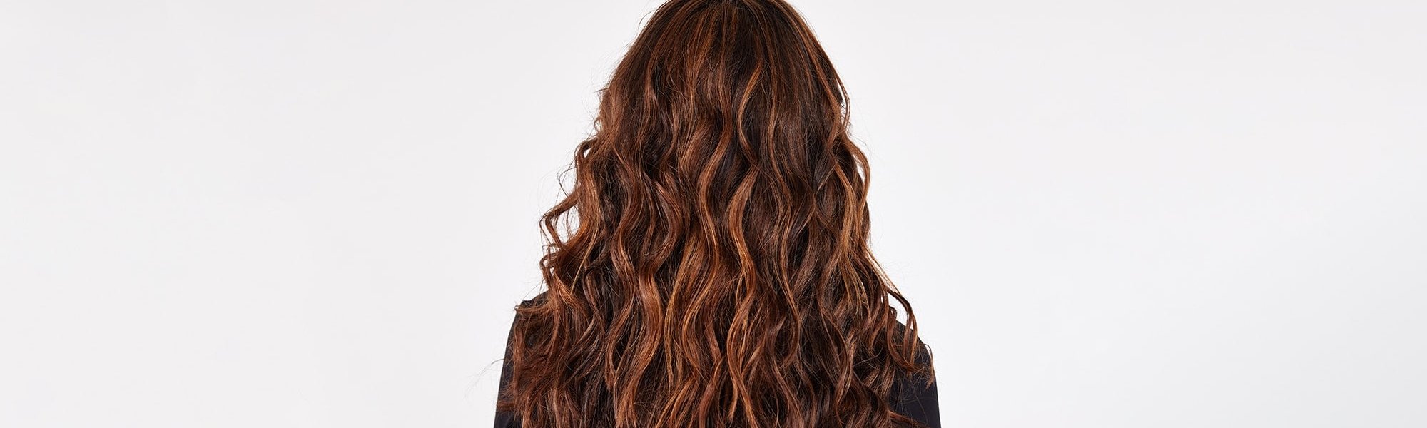 Rückansicht einer Frau mit langen gewellten braunen Haaren