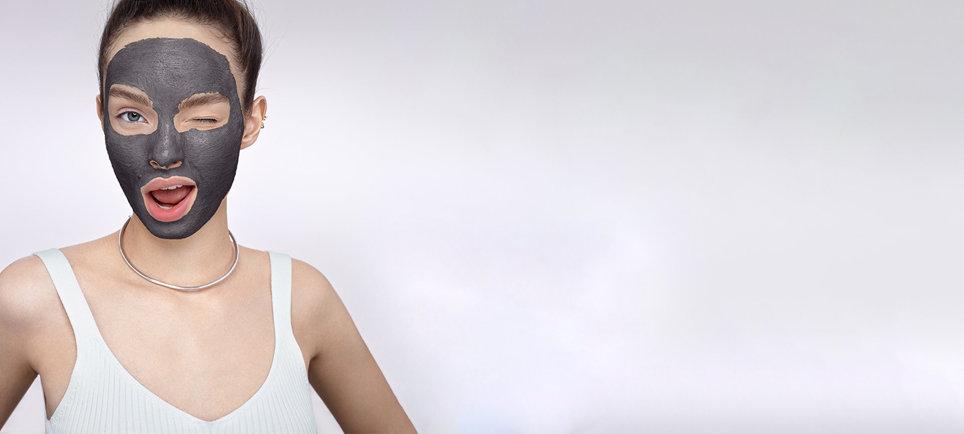 Frau mit dunkler Gesichtsmaske zwinkert in die Kamera