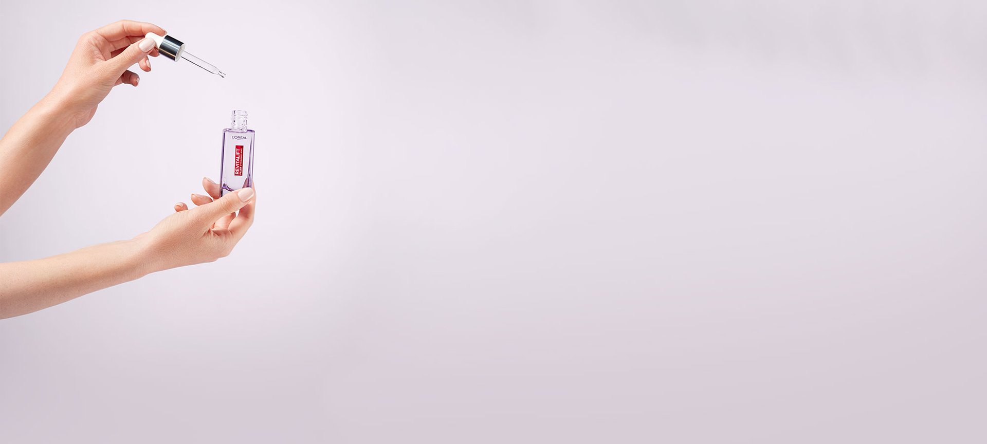 Zwei Hände einer Frau halten die geöffnete Ampulle und die Pipette von Revitalift Filler Anti-Falten Serum mit 1,5% purer Hyaluronsäure