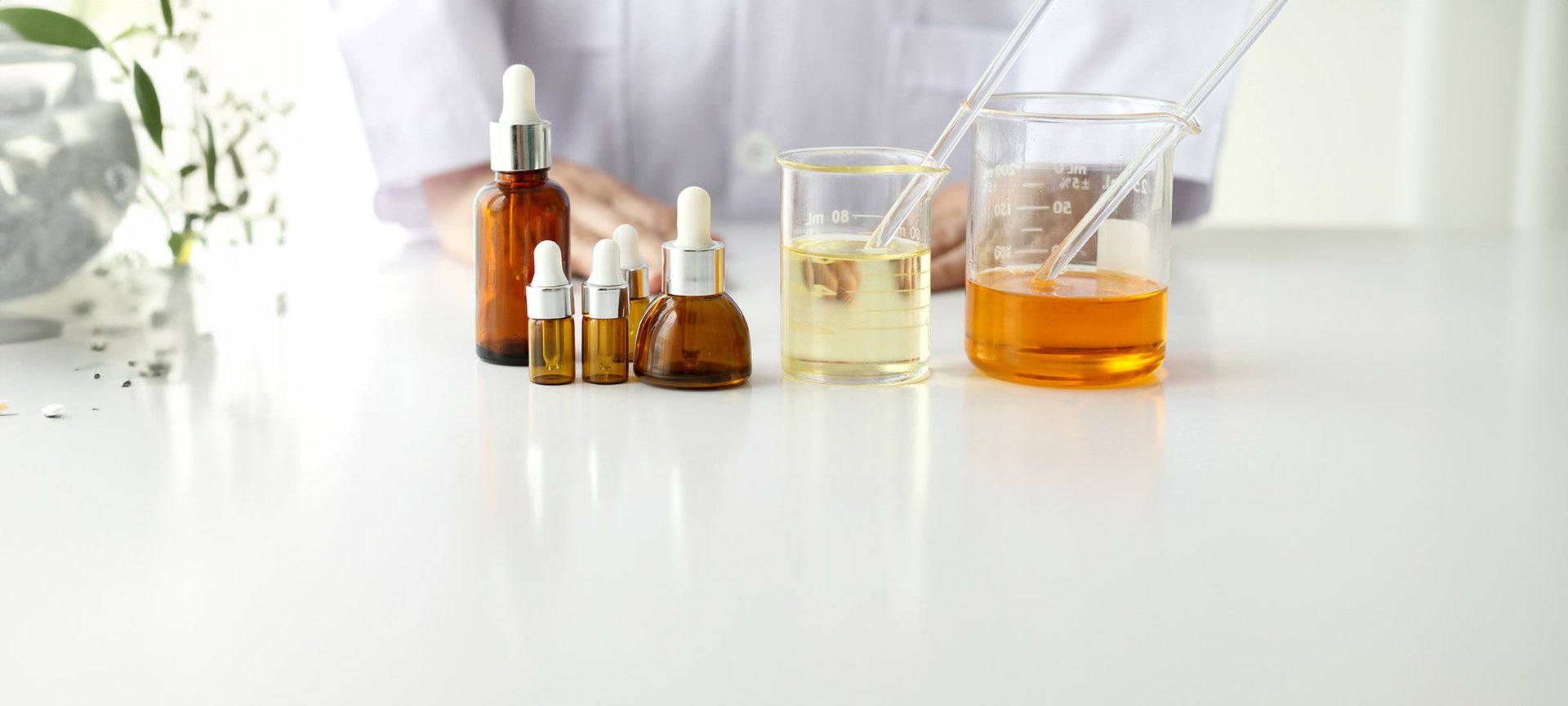 Stillleben mit einigen Fläschchen mit Serum und zwei Gläser mit goldener und orangener Flüssigkeit