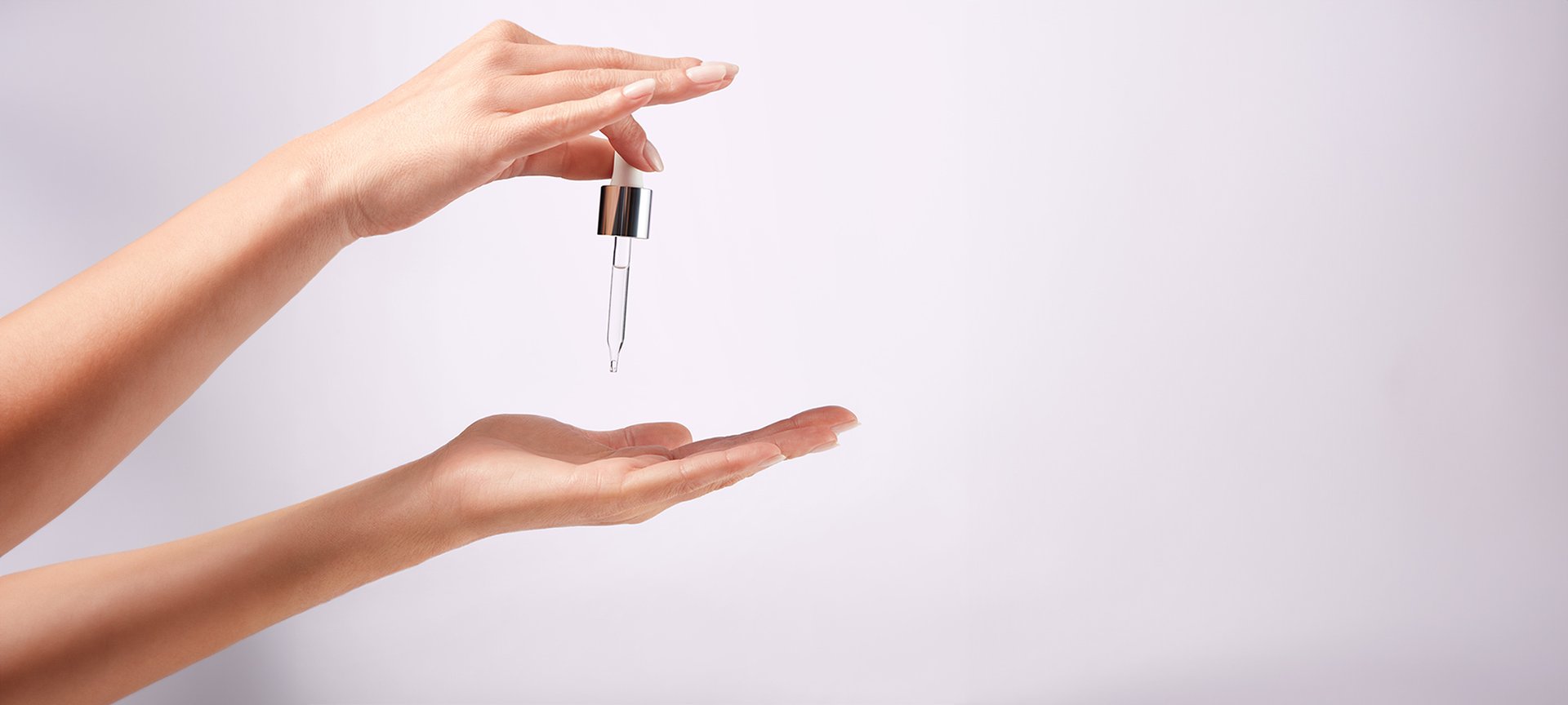 Eine rechte Hand einer Frau hält die Pipette von Revitalift Filler Anti-Falten Serum mit 1,5% purer Hyaluronsäure und tropft Serum auf die linke Handfläche