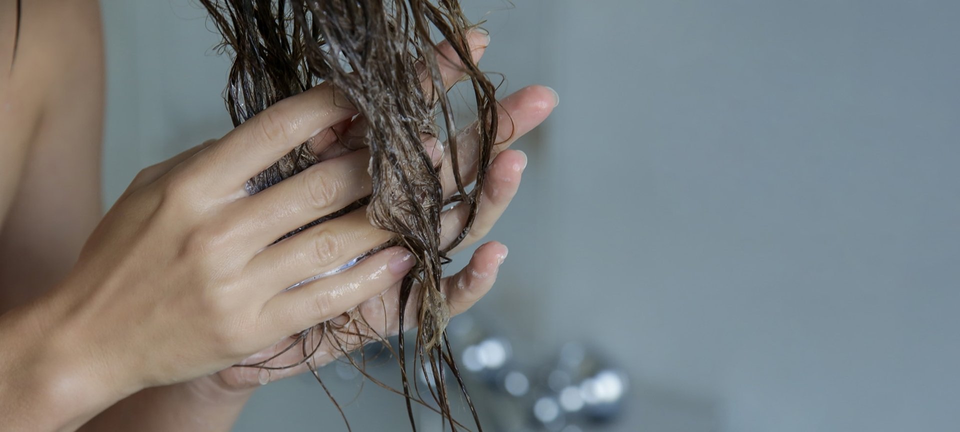 Eine Frau verteilt die Spülung im Haar