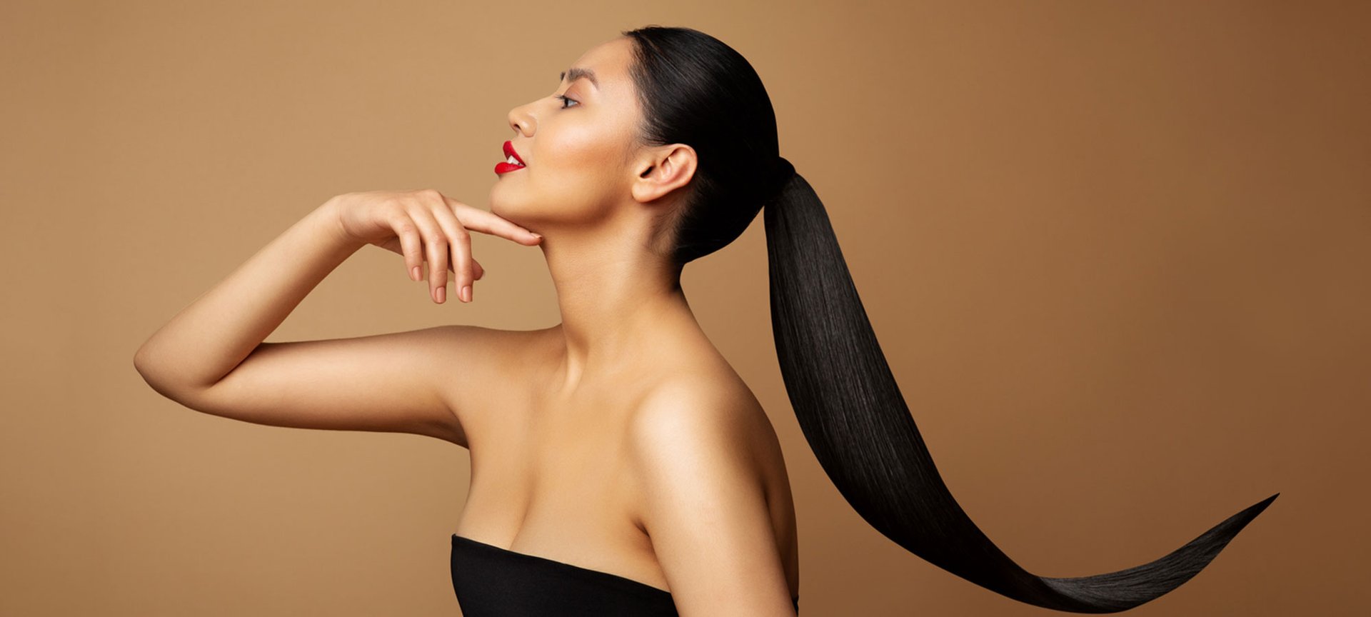 Eine Frau in Profilansicht mit langen zusammengebunden schwarzen Haaren