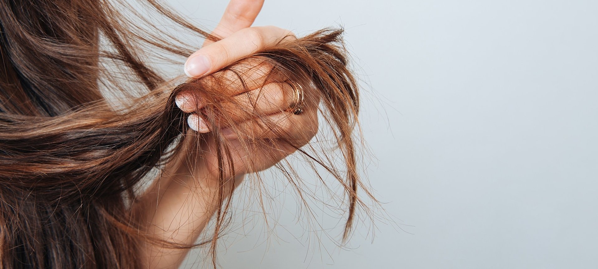 Eine Frau fährt sich mit der Hand durch ihre langen braunen haare