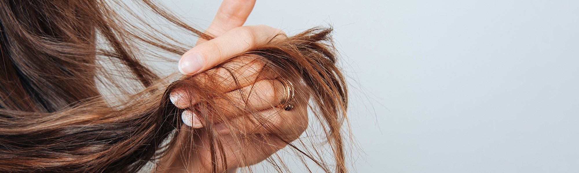 Eine Frau fährt sich mit der Hand durch ihre langen braunen haare