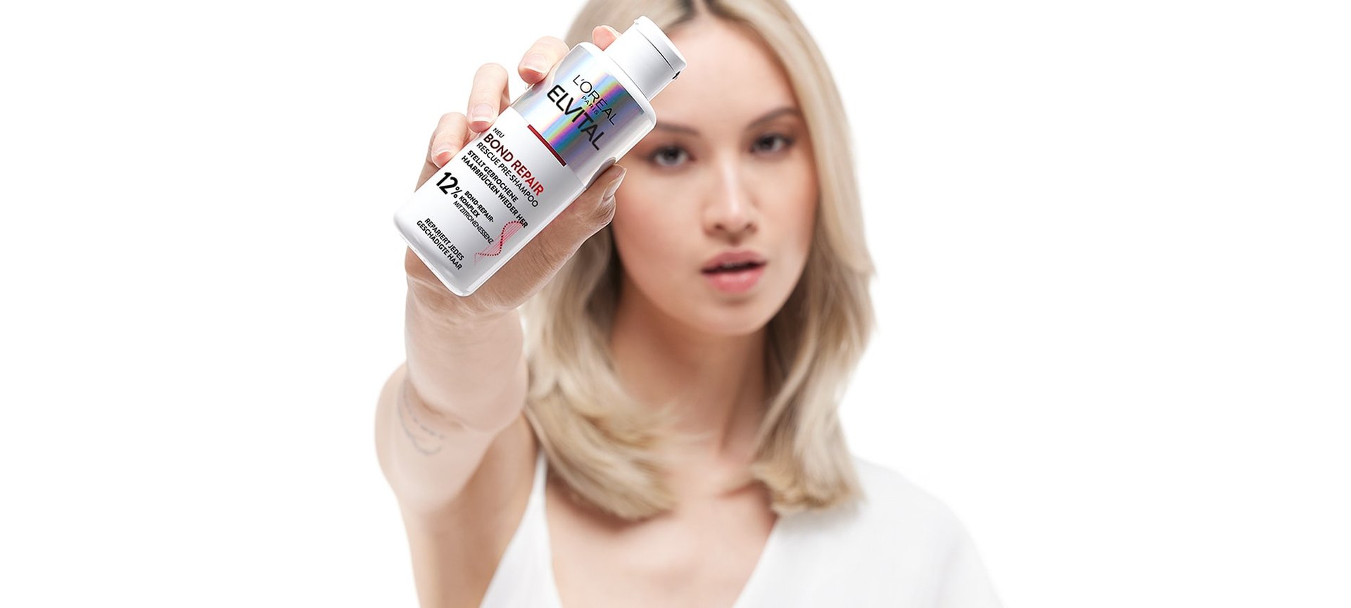 Eine Frau hält ein Elvital Bond repair in ihrer Hand