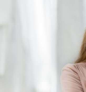 Eine Frau trägt auf ihre rechte Wange eine Creme auf