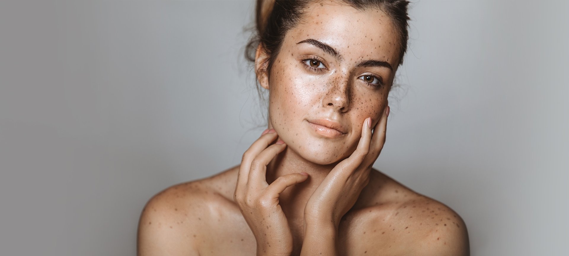 Brünette Frau hält ihre Hände an die Wangen