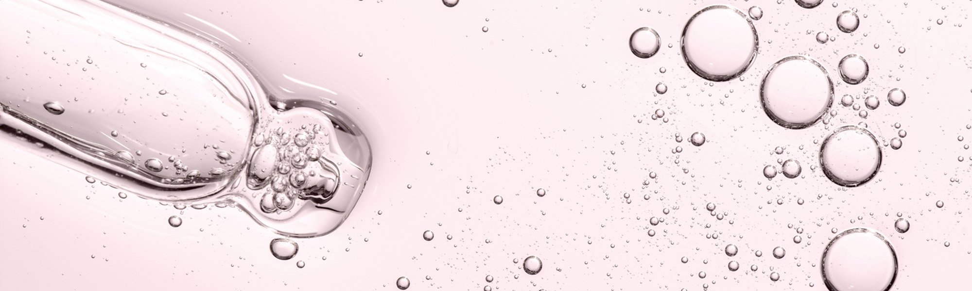 Detailaufnahme einer transparenten rosa Flüssigkeit mit einigen Luftblasen