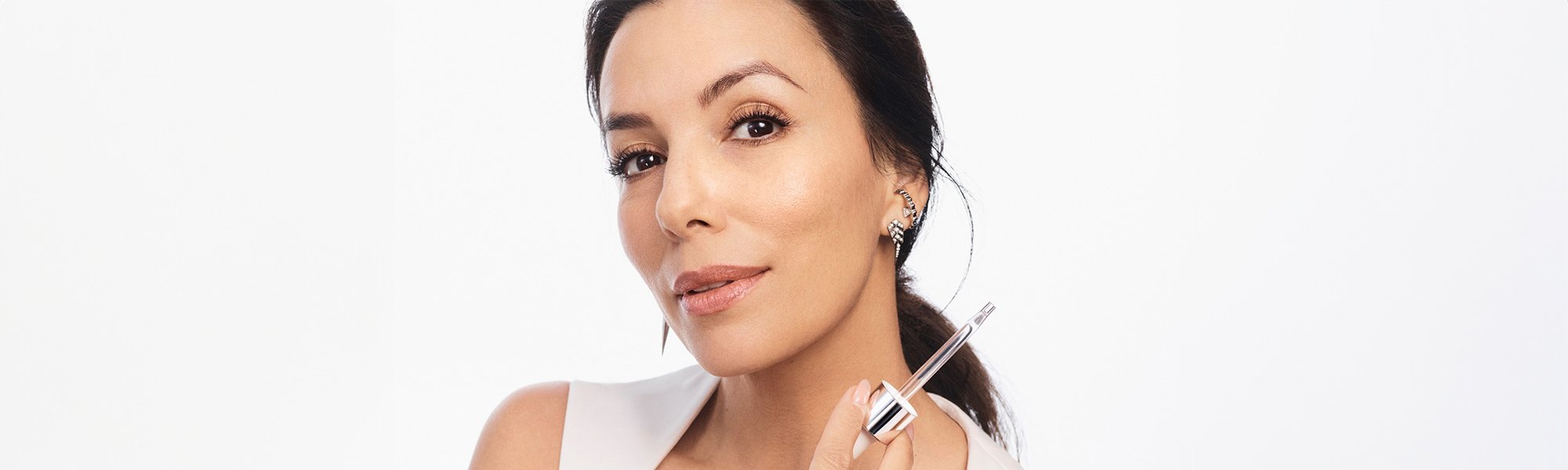 Eva Longoria hält eine Pipette in ihrer rechten Hand von einem L'Oréal Serum