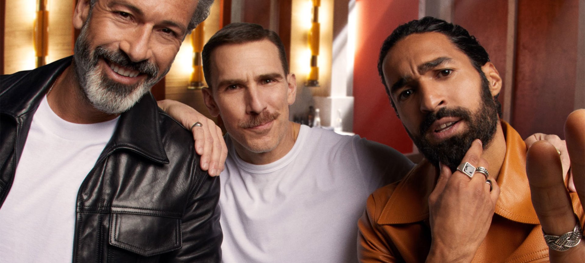 Drei Männer mit verschiedenen Bartformen schauen interessiert