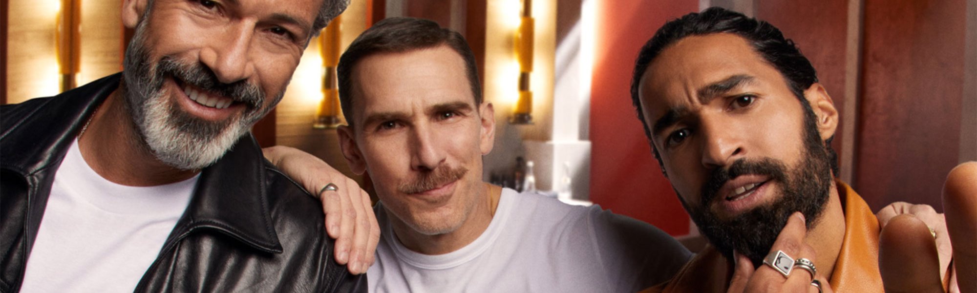 Drei Männer mit verschiedenen Bartformen schauen interessiert