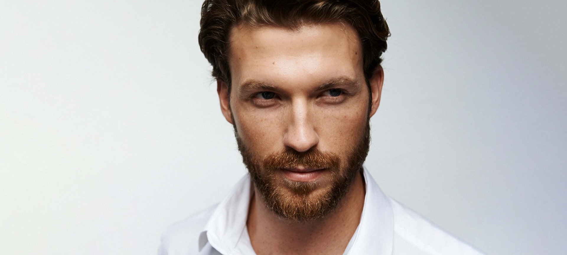 Mann mit Bart blickt in die Kamera