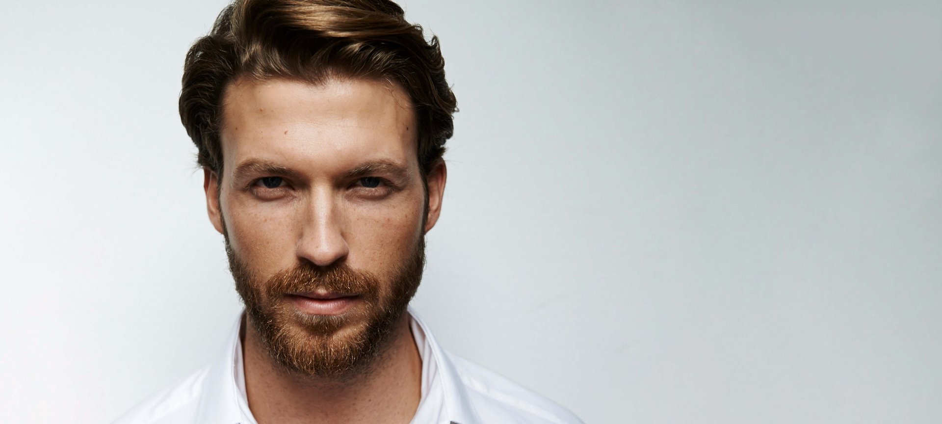 Mann mit Bart blickt in die Kamera