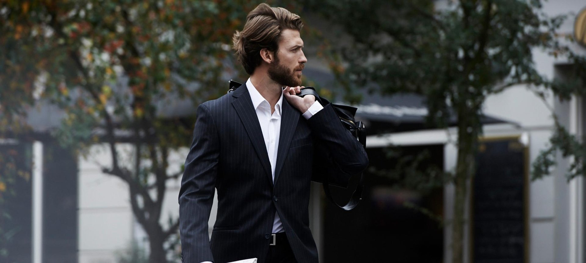 Mann mit Bart im seitlichen Profil und Hand am Kinn