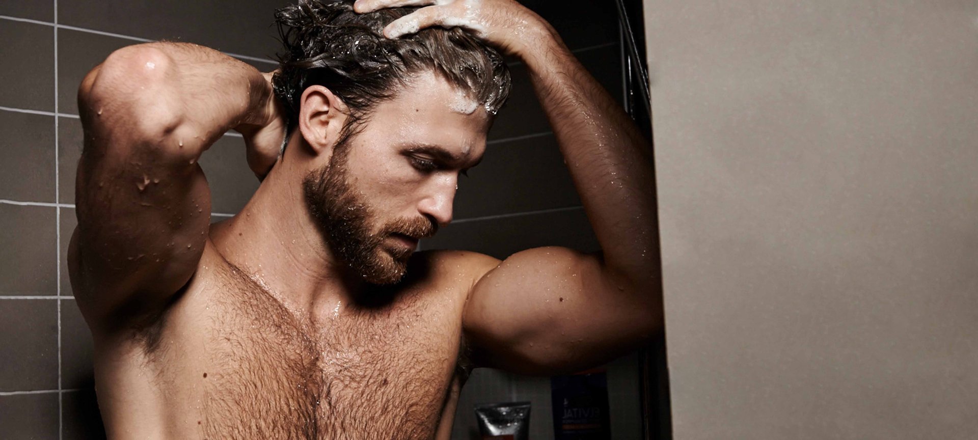 Ein Mann mit Vollbart unter der Dusche