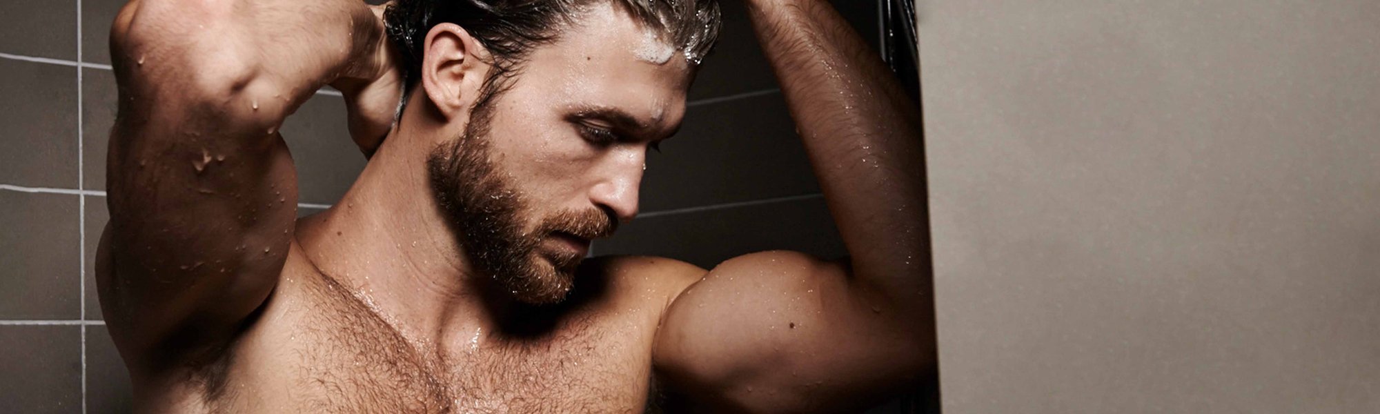 Ein Mann mit Vollbart unter der Dusche