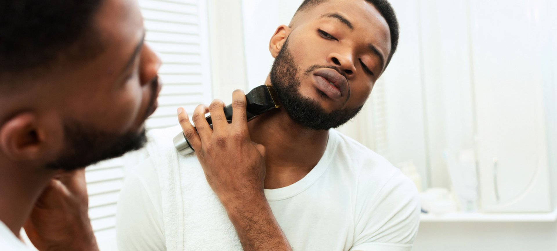 Ein Mann steht vor dem Spiegel und rasiert sich