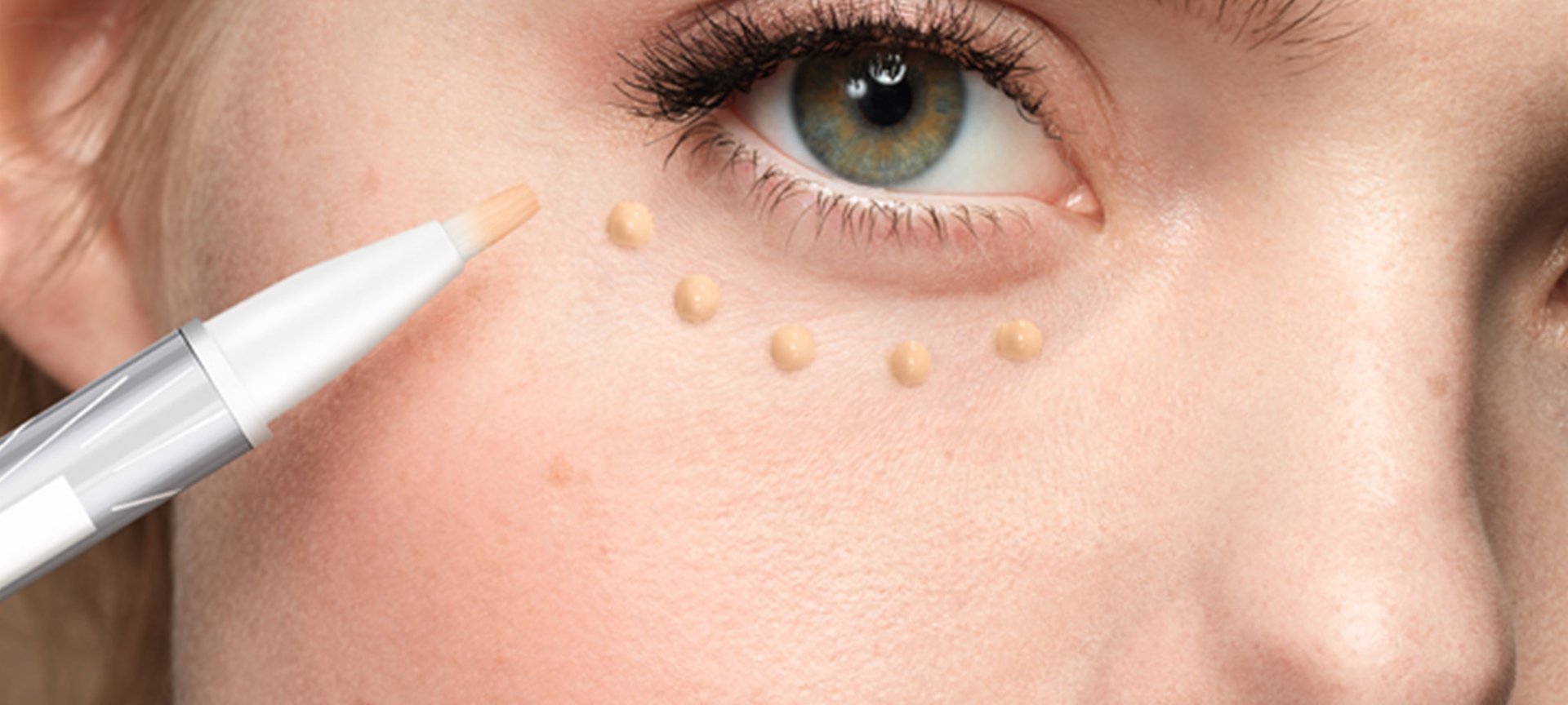 Frau trägt sich Concealer auf