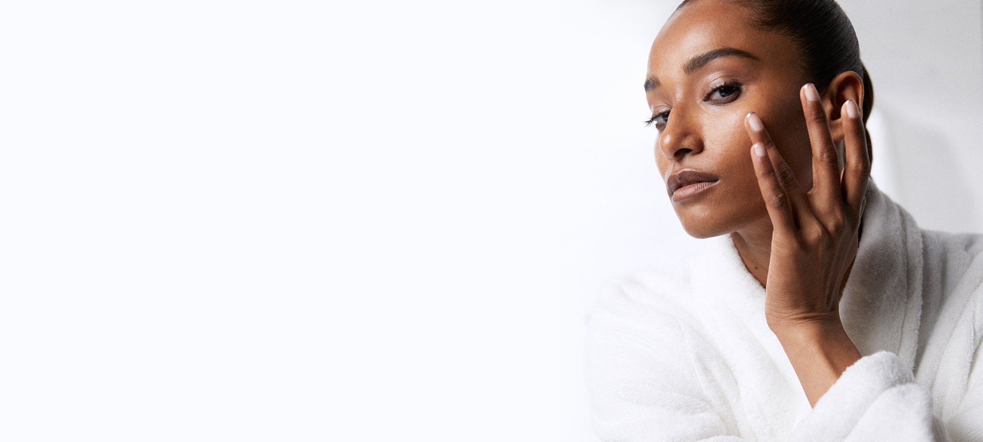 Eine junge Frau mit Make-up betrachtet im Spiegel