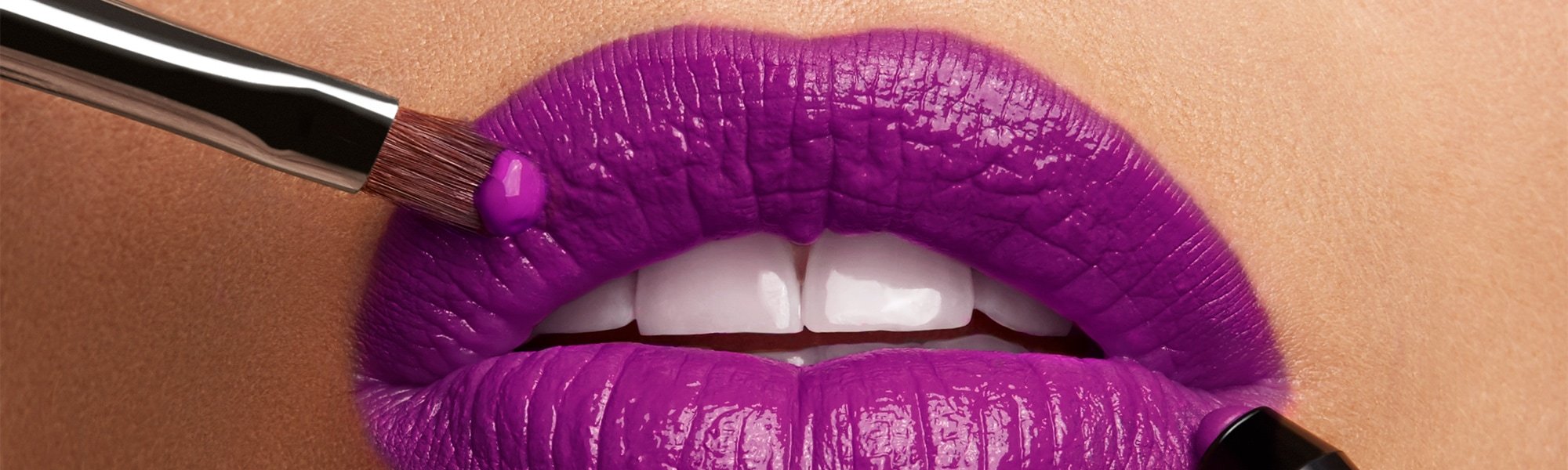 Volle Lippen werden mit Stift und Pinsel violett geschminkt