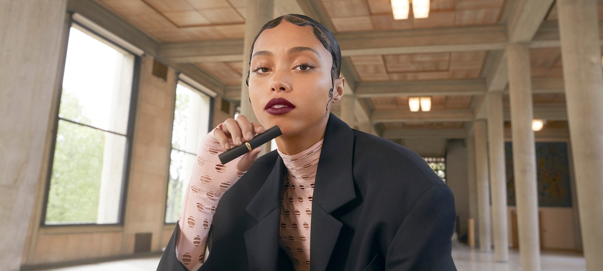 Ein Model trägt matten Lippenstift und hält die Hülse in der Hand