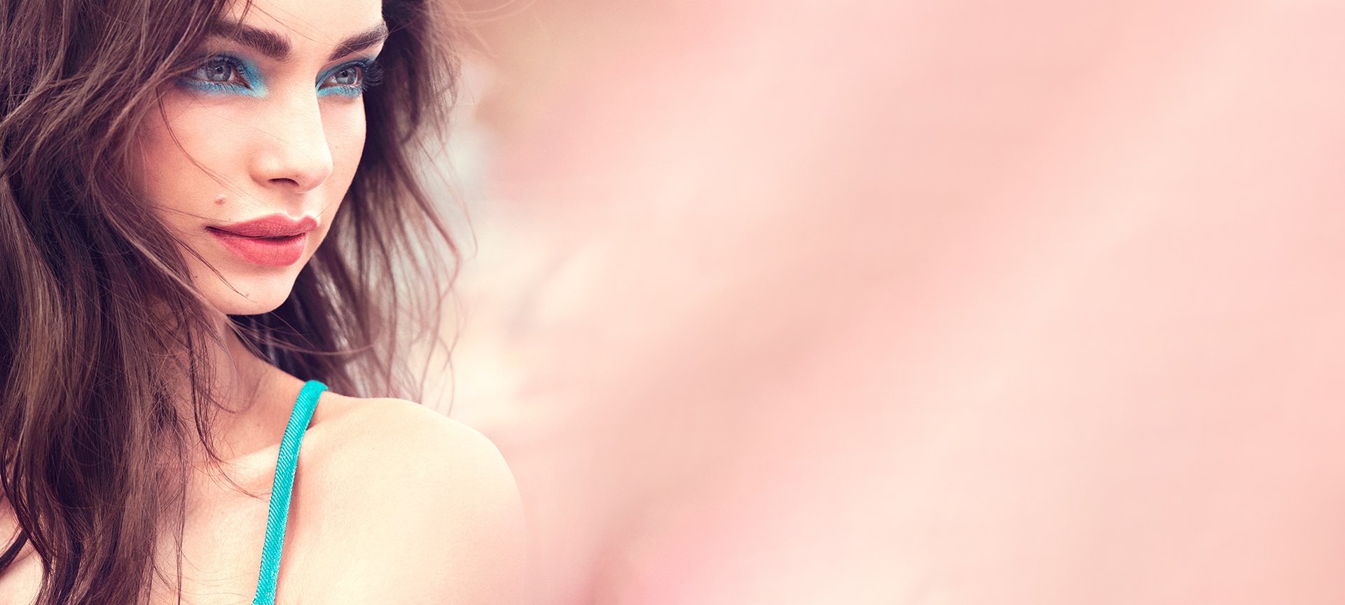 Junge Frau mit Rouge auf ihren Wangen und türkisfarbenen Augen Make-up