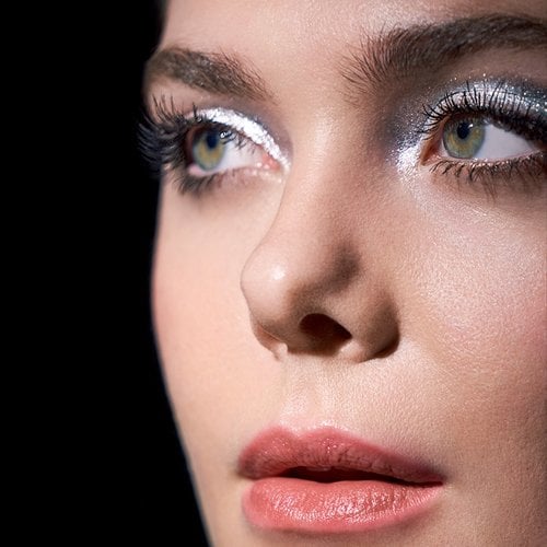 Eine junge Frau mit Smokey Eyes Make-up vor schwarzem Hintergrund