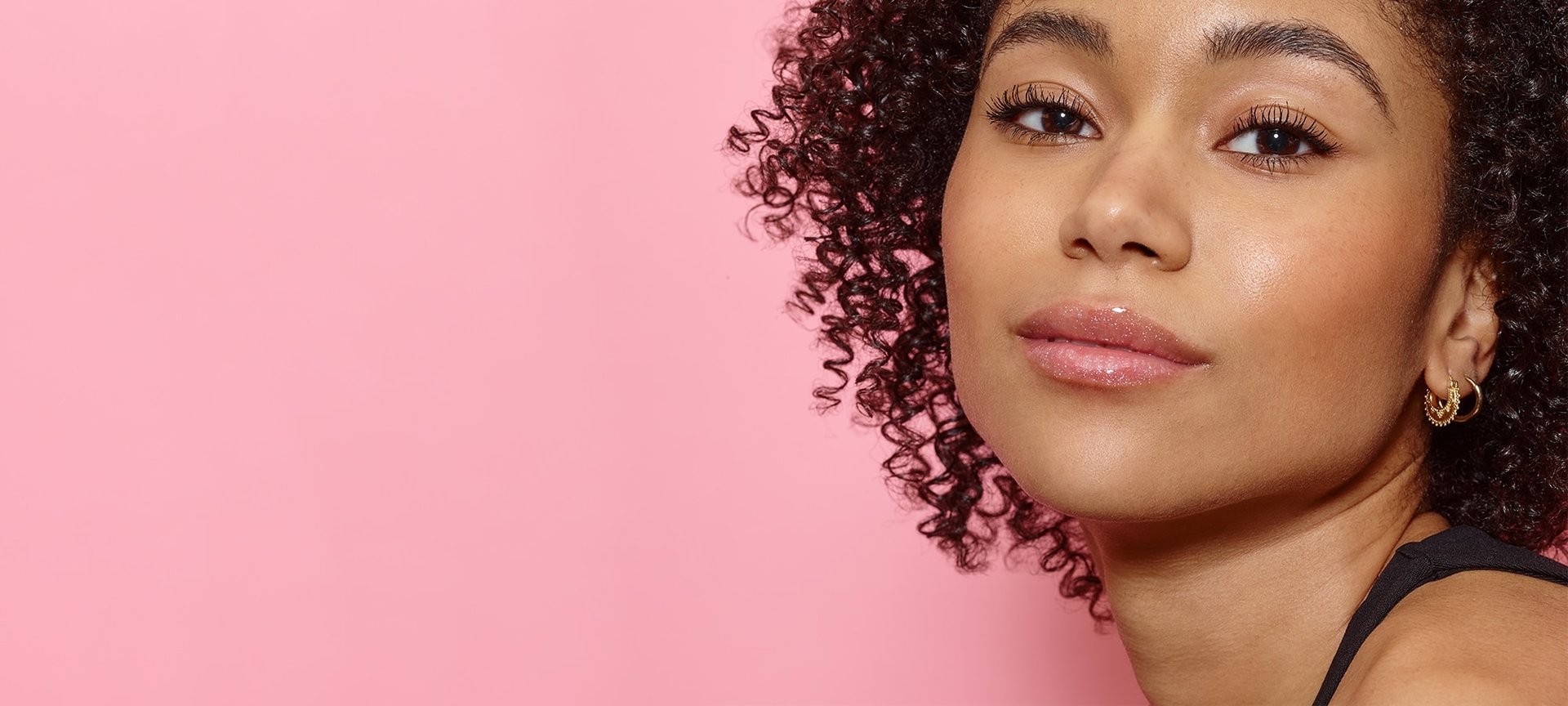 Eine junge Frau mit lockigen Haaren und dezentem Make-up