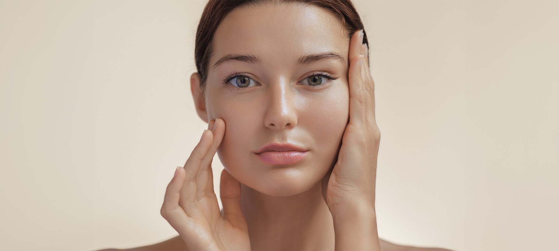 Strobing: Junge Frau präsentiert ihr konturiertes Gesicht. Ihre Hände rahmen ihr Gesicht.