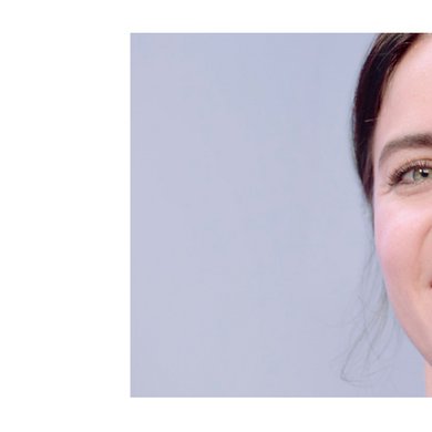 Dunkelhaarige Frau lächelt in die Kamera
