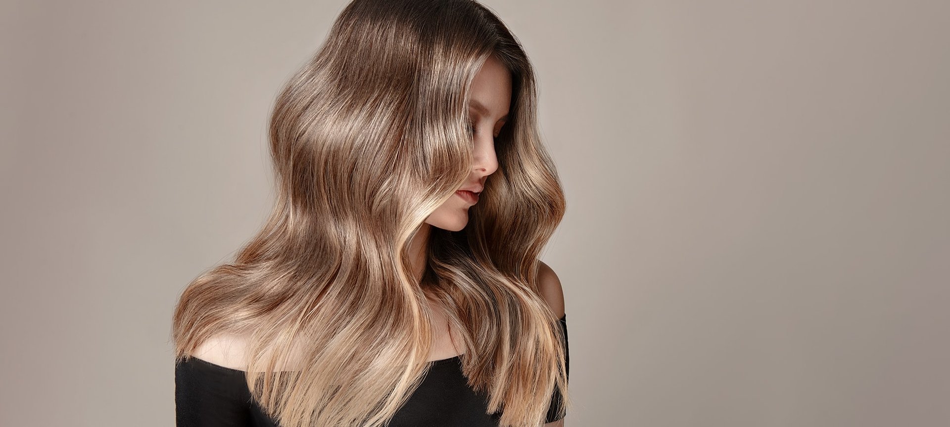 Junge Frau mit langen dunkelblonden Haaren schaut über ihre linke Schulter