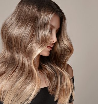 Junge Frau mit langen dunkelblonden Haaren schaut über ihre linke Schulter