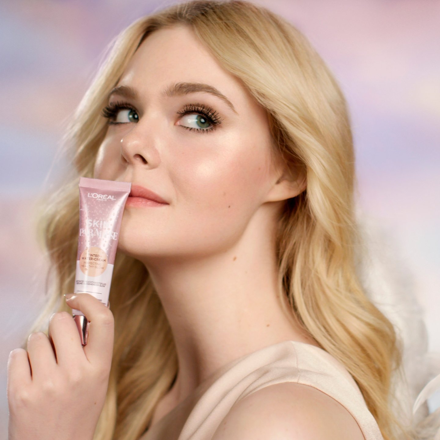 Junge Frau mit langen blonden Haaren hält ein Make-up Produkt in ihrer Hand