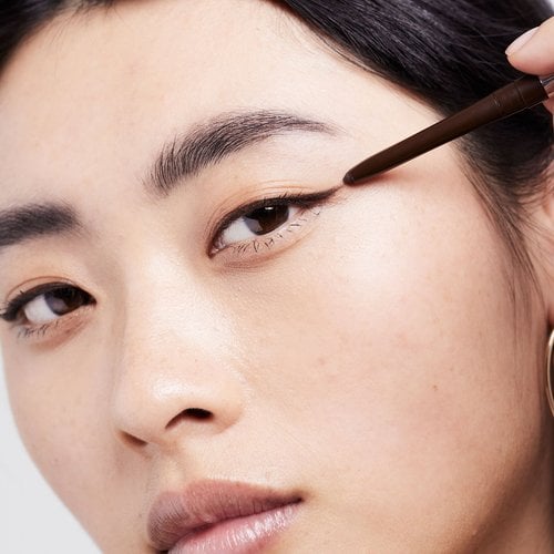 Eine junge Frau trägt einen schwarzen Eyeliner auf