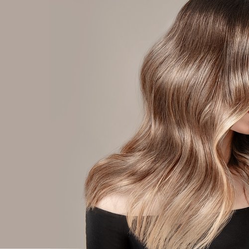 Model mit blondem welligen Haar schaut zur Seite