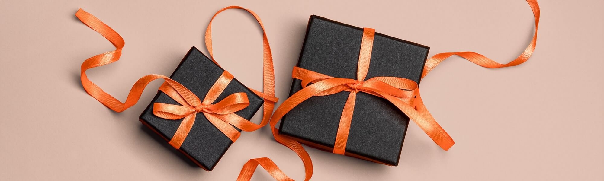 Schwarze Geschenkboxen mit orangenen Schleifen