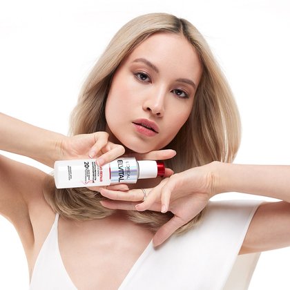 Model haelt Loreal Elvital Bond Repair Serum in ihren Haenden