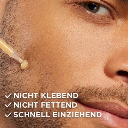 Mann trägt Serum aus der Pipette auf seine Wange auf