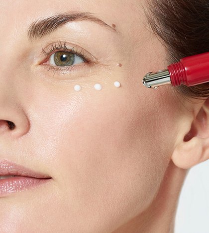 Brünette Frau traegt die Revitalift Laser X3 Anti Age Augencreme auf
