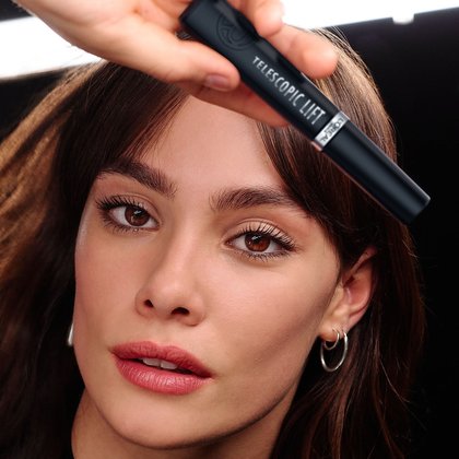Eine Frau hält den Mascara in der Hand